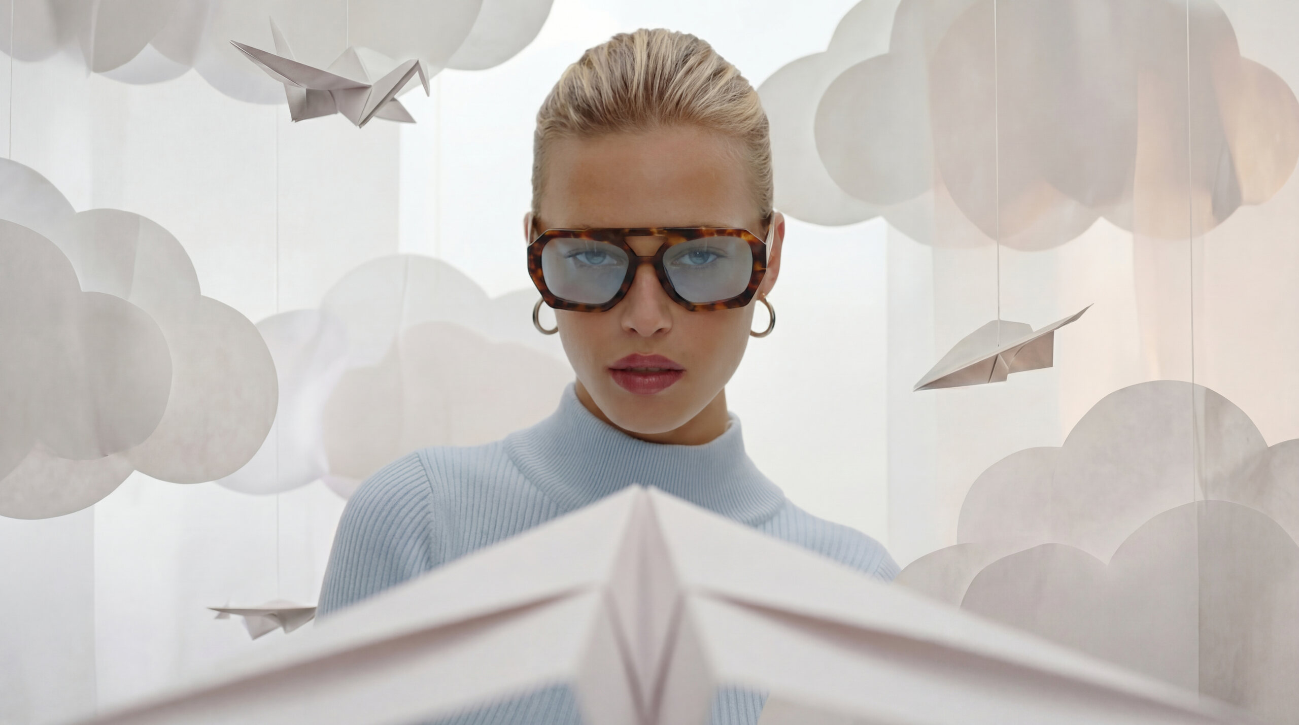 Donna con occhiali da sole e aeroplano di carta